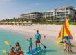 Soft white sandy beach at Jumeirah Saadiyat Island Resort with families in water