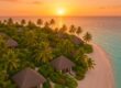 Private island with beachside villas and lush tropical gardens at sunset