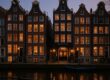 Pulitzer Amsterdam historic canal houses illuminated at dusk
