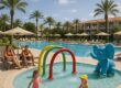 Family-friendly resort pool with kids area and parents relaxing