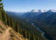 Panoramic mountain trail showing forests, peaks, river
