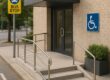 Accessible hotel entrance with wheelchair ramp beside public transit stop