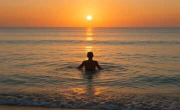 Solo swimmer at calm sunrise beach