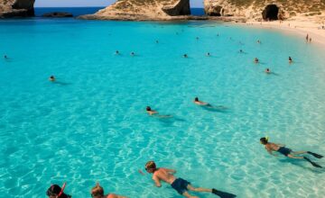Blue Lagoon Bay with sandy beach and snorkeling visitors