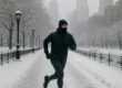 Runner in thermal gear running on snow-covered urban park path