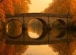 Historic stone bridge at golden hour with calm water reflections
