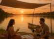 Couple enjoying a shaded picnic and calm paddle on a lake at sunset